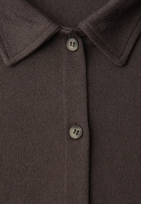 Nahaufnahme einer dunkelbraunen Strickjacke mit Hemdblusenkragen und zwei Knöpfen.